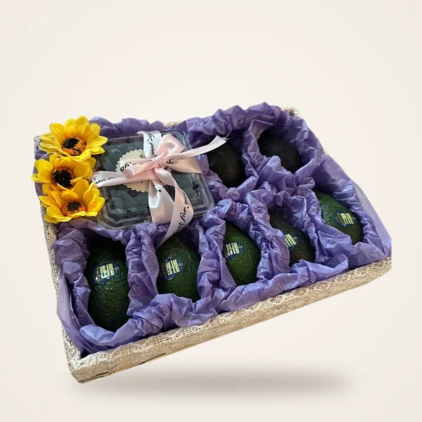 Avocado & Blueberry Sunflower Gift Tray - avocados and blueberries in purple tissue with sunflowers and a pink ribbon