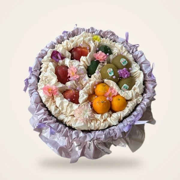 Lilac Ruffle Round Fruit Gift Box - kiwi, oranges, apples and flowers in a round box with lilac ruffle