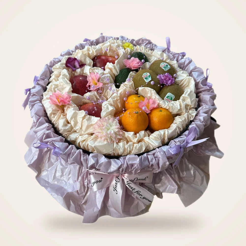 Lilac Ruffle Round Fruit Gift Box - kiwi, oranges, apples and flowers in a round box with lilac ruffle (view 2)