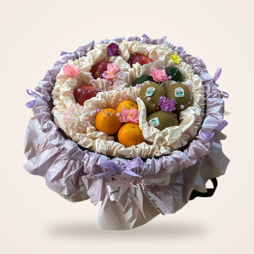 Lilac Ruffle Round Fruit Gift Box - kiwi, oranges, apples and flowers in a round box with lilac ruffle (view 3)