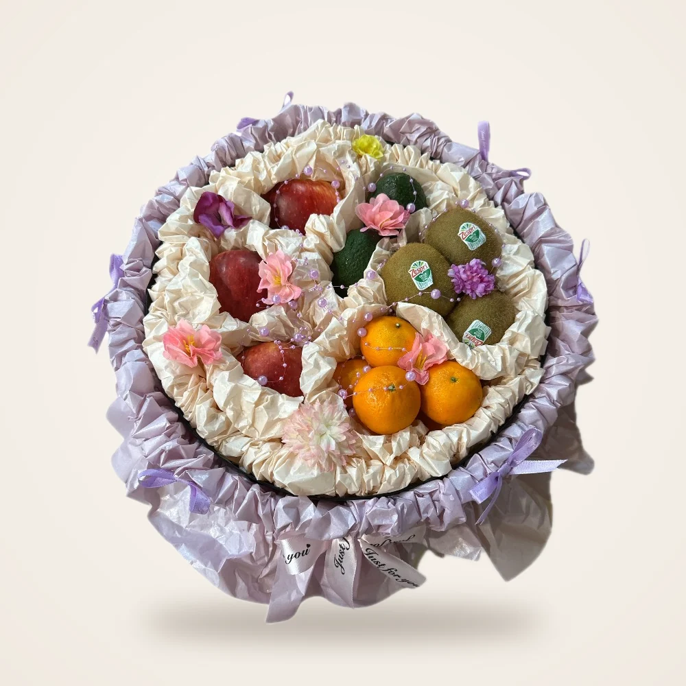 Lilac Ruffle Round Fruit Gift Box - kiwi, oranges, apples and flowers in a round box with lilac ruffle