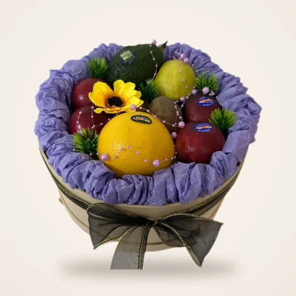 Orange & Sunflower Hatbox Fruit Basket - orange, apples and avocado with a sunflower in a round hatbox with purple ruffle