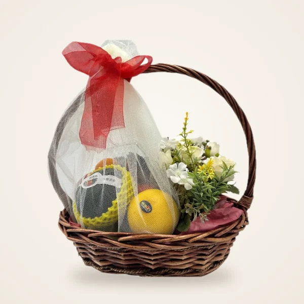 Red Ribbon Melon & Orange Fruit Basket - melon, orange and flowers in a wrapped woven basket with a red ribbon